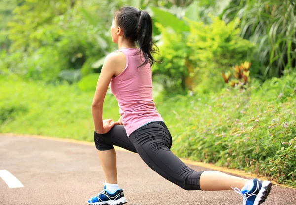 Mulher esticando as pernas antes de correr — Fotografia de Stock