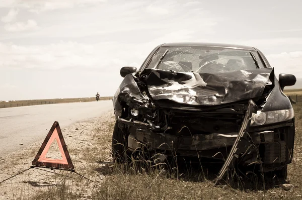 Carro de acidente e triângulo de aviso ao lado da estrada — Fotografia de Stock