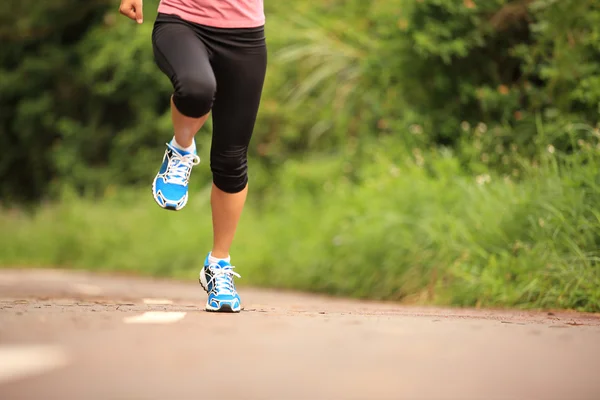 Oung fitness piernas de mujer corriendo en el sendero del bosque — Foto de Stock