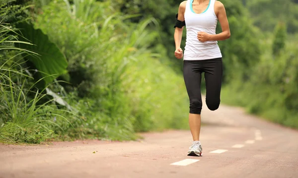 Joven mujer de fitness corriendo por el sendero forestal — Foto de Stock