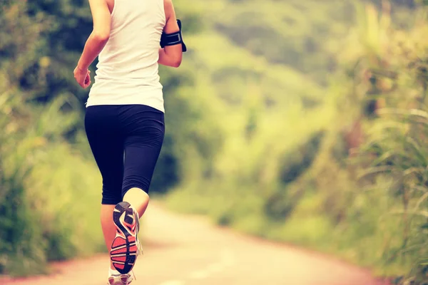 Молодая фитнес-женщина бегает по лесной тропе — стоковое фото