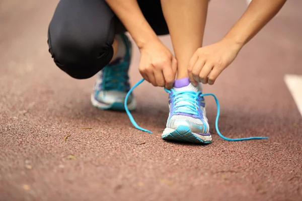 Giovane donna corridore allacciatura lacci delle scarpe — Foto Stock