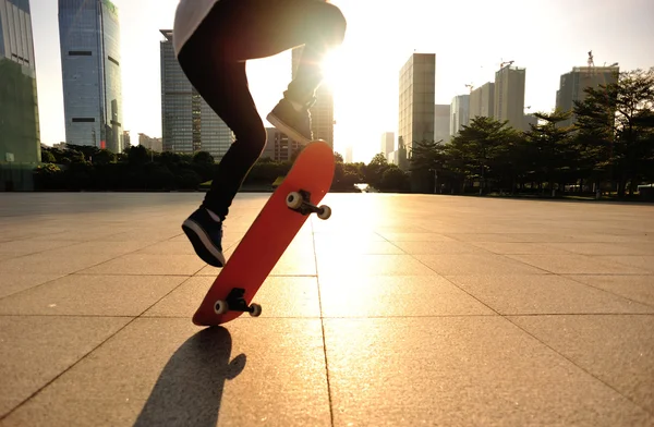 Femme skateboard skateboard au lever du soleil ville — Photo