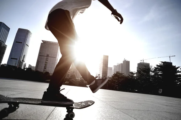 Femme skateboard skateboard au lever du soleil ville — Photo