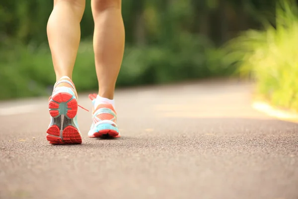 Jeune femme fitness jambes en cours d'exécution au sentier forestier — Photo