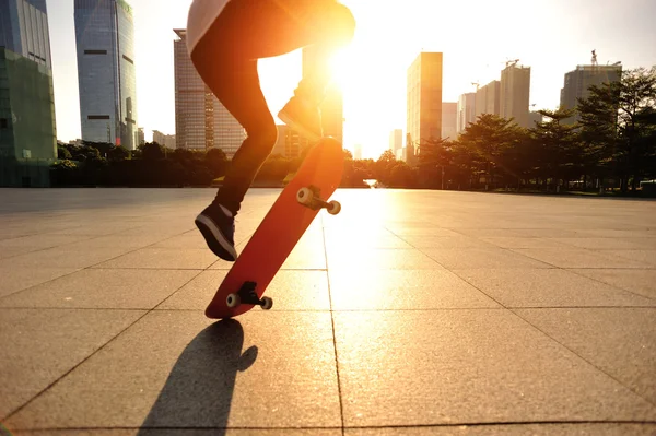 Femme skateboard skateboard au lever du soleil ville — Photo