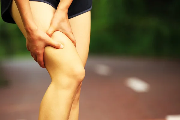 Woman runner hold her injured leg — Stock Photo, Image