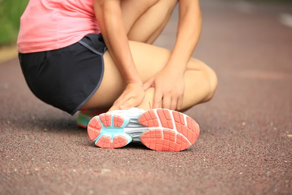 Woman runner hold her twisted ankle — Stock Photo, Image