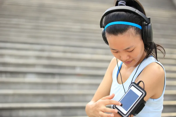 Atleta corredor ouvir música em fones de ouvido a partir de telefone inteligente mp3 jogador braçadeira de telefone inteligente . — Fotografia de Stock