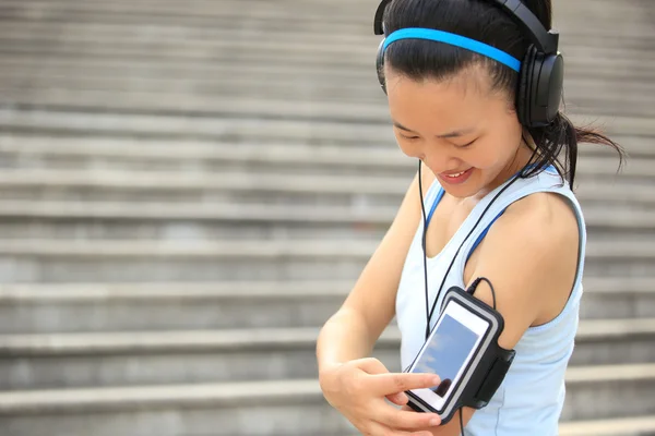 Atleta corredor ouvir música em fones de ouvido a partir de telefone inteligente mp3 jogador braçadeira de telefone inteligente . — Fotografia de Stock