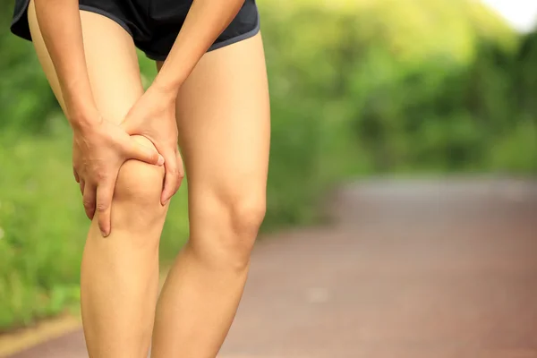 Woman runner hold her injured leg — Stock Photo, Image