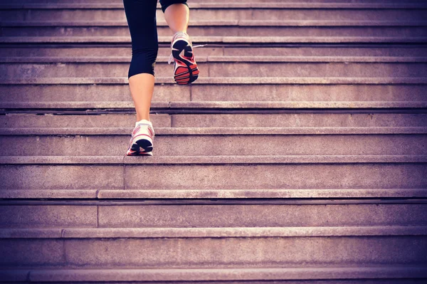 Sports woman legs running up on stone stairs — Stock Photo, Image