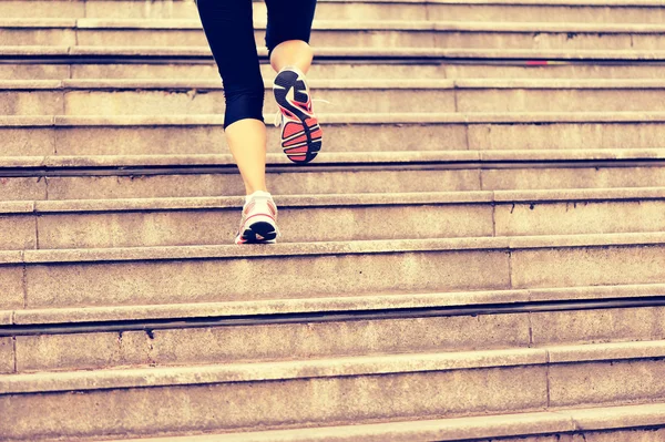 Sports woman legs running up on stone stairs — Stock Photo, Image