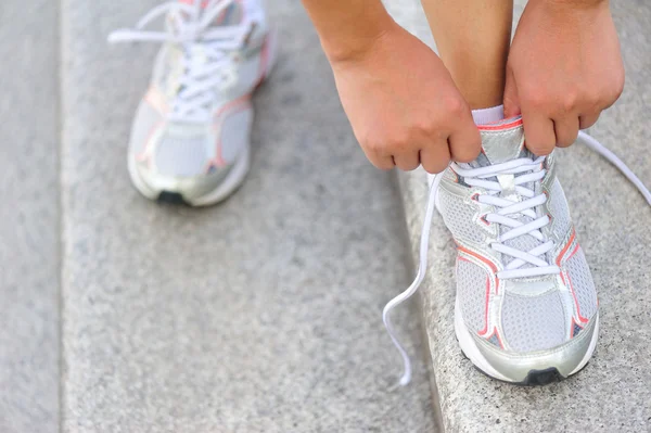 Joven corredora atando cordones en las escaleras — Foto de Stock