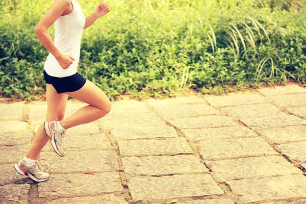 Joven mujer de fitness corriendo por el sendero forestal — Foto de Stock