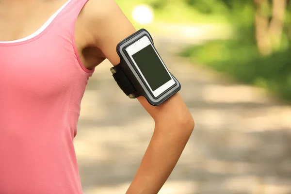 Runner atleet luisteren naar muziek van slimme telefoon mp3 speler slimme telefoon armband. — Stockfoto