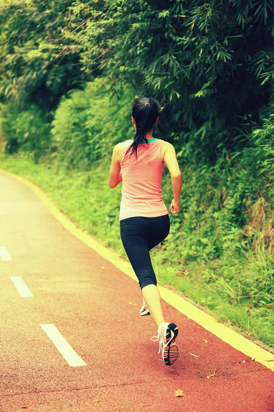 Joven mujer de fitness corriendo por el sendero forestal — Foto de Stock