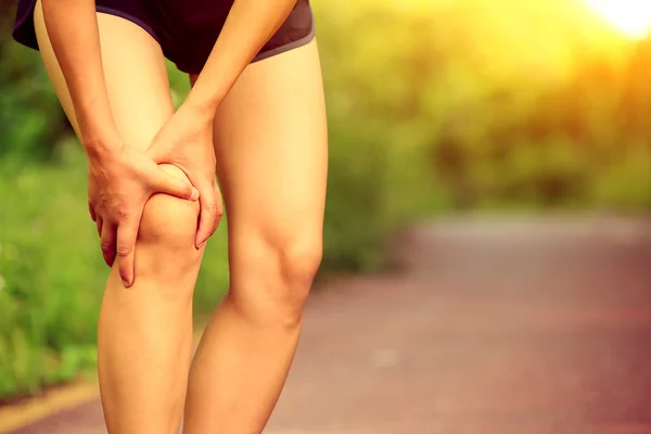 Woman runner hold her injured leg — Stock Photo, Image