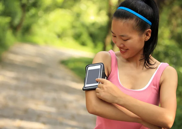 Corredor atleta escuchando música de teléfono inteligente reproductor de mp3 brazalete de teléfono inteligente . —  Fotos de Stock