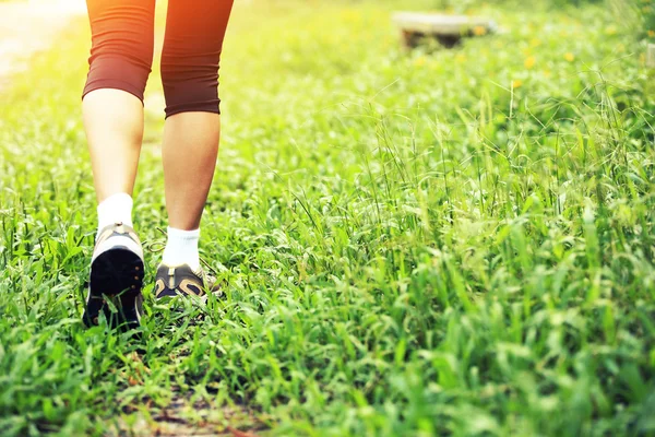 Correndo caminhadas pernas na grama verde — Fotografia de Stock