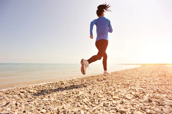 Runner athlete running on stone beach of qinghai lake. — Stock Photo, Image