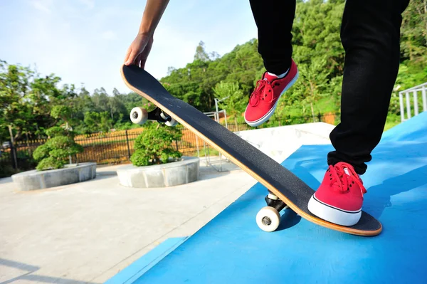 Skateboarding žena nohy při východu slunce skatepark — Stock fotografie