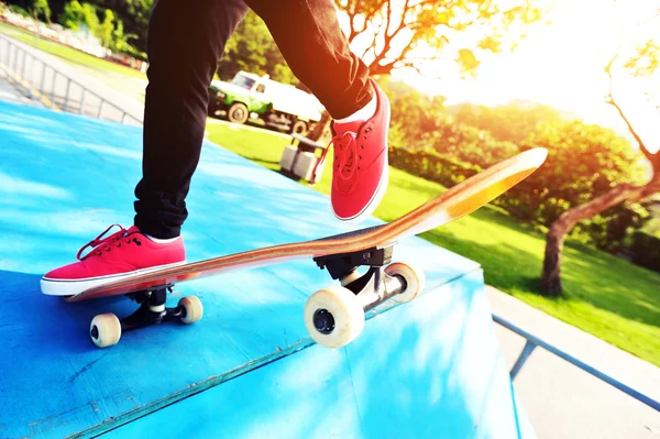 Kaki wanita Skateboarding di taman skatepark matahari terbit — Stok Foto