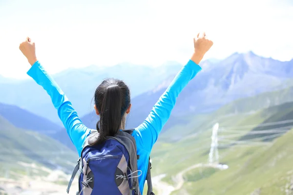 Animar a la mujer senderismo brazos abiertos en la cima de la montaña del Tíbet, China —  Fotos de Stock