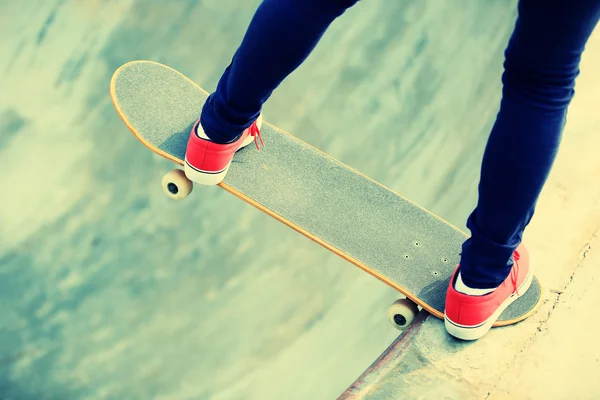 Skateboarding pernas de mulher no skatepark — Fotografia de Stock