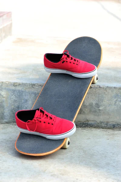 Skateboard y zapatillas en skatepark —  Fotos de Stock