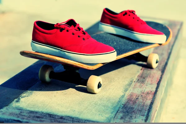 Skateboard and sneakers at skatepark — Stock Photo, Image