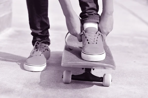 Junge Skateboarderin bindet Schnürsenkel — Stockfoto