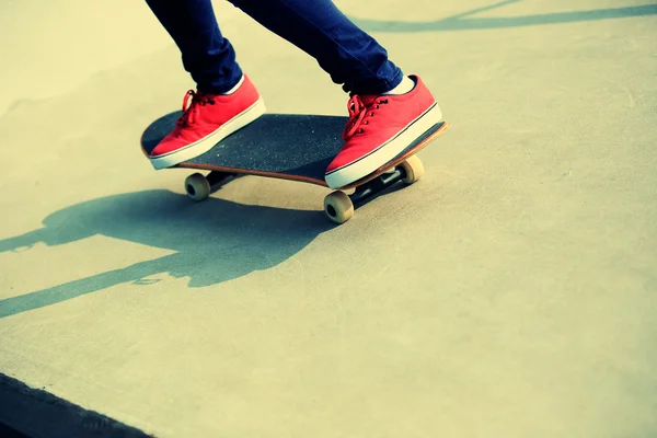 Kobieta nogi jazda na deskorolce w rampę skatepark — Zdjęcie stockowe