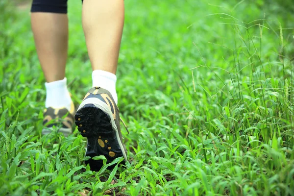 Jeune femme fitness jambes en cours d'exécution au sentier forestier — Photo