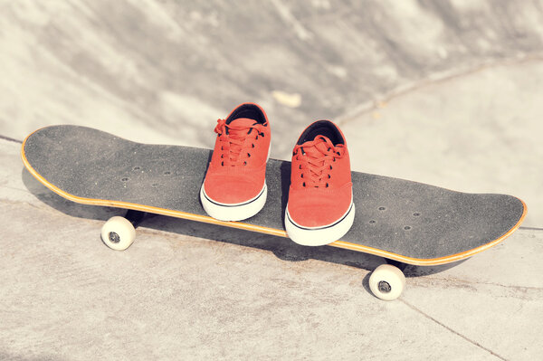 Skateboard and sneakers at skatepark