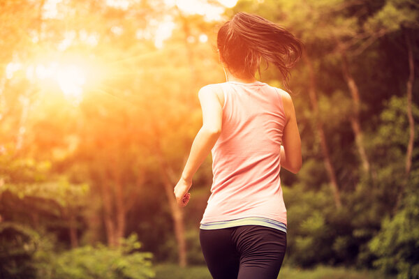 Woman running at forest trail