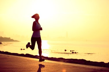 Deniz kenarında çalışan runner atlet. kadın fitness siluet gündoğumu koşu egzersiz sağlık kavramı.