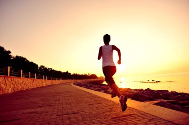 Deniz kenarında çalışan runner atlet. kadın fitness siluet gündoğumu koşu egzersiz sağlık kavramı.