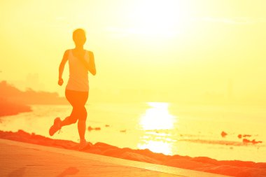 Deniz kenarında çalışan runner atlet. kadın fitness siluet gündoğumu koşu egzersiz sağlık kavramı.