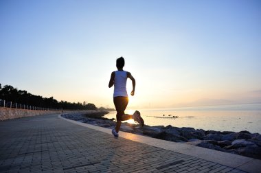 Deniz kenarında çalışan runner atlet. kadın fitness siluet gündoğumu koşu egzersiz sağlık kavramı.