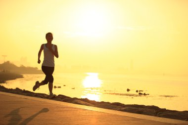 Deniz kenarında çalışan runner atlet. kadın fitness siluet gündoğumu koşu egzersiz sağlık kavramı.