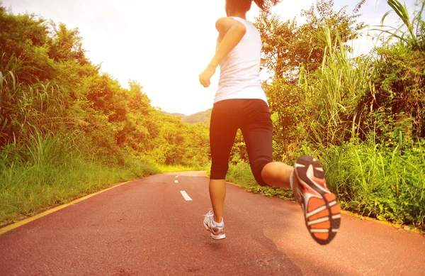 Mujer corriendo en el sendero forestal — Foto de Stock