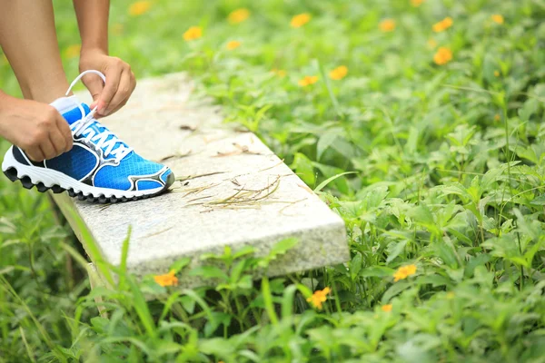 Woman runner tying shoelaces — Stock Photo, Image