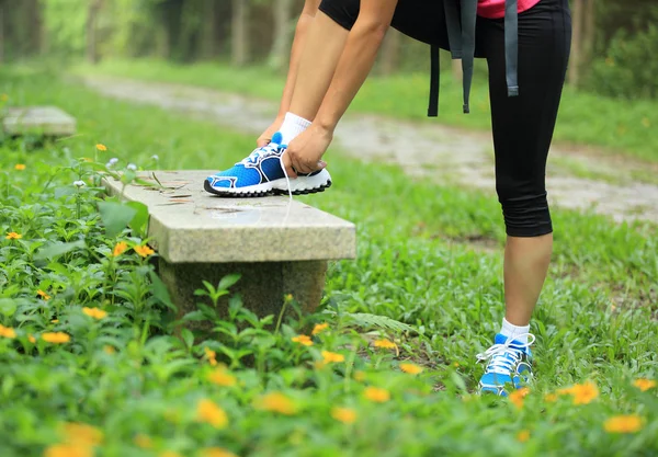 Woman runner tying shoelaces — Stock Photo, Image