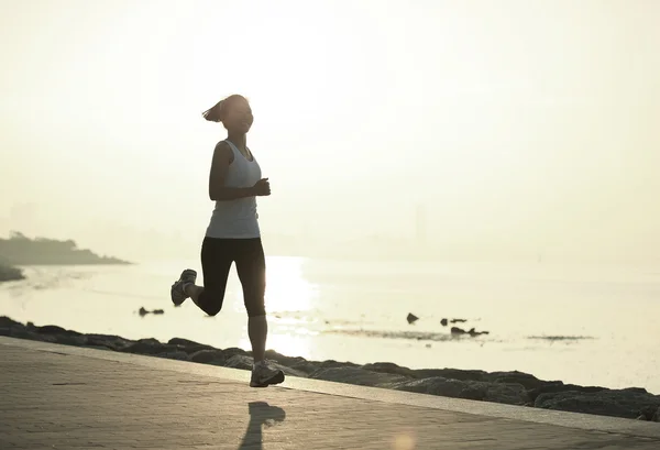Löpare idrottsman kör på seaside. kvinna fitness silhuett sunrise jogging träning wellness koncept. — Stockfoto