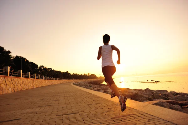 Atleta corredor corriendo a la orilla del mar. mujer fitness silueta amanecer trotar entrenamiento bienestar concepto . —  Fotos de Stock