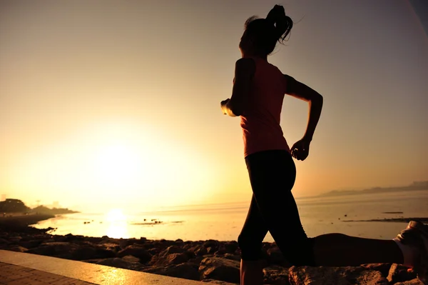 Atlet pelari lari di tepi pantai. Wanita kebugaran siluet matahari terbit jogging latihan kesehatan konsep . — Stok Foto