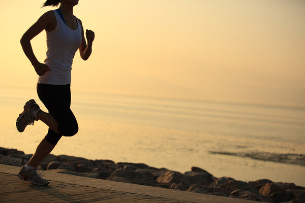 Runner athlete running at seaside. woman fitness silhouette sunrise jogging workout wellness concept.