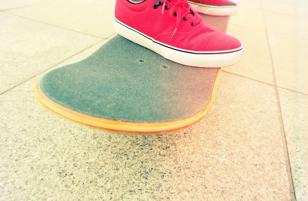 Skateboard and sneakers — Stock Photo, Image