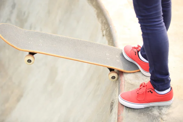 Mladá žena nohy skateboardingu skatepark rampa — Stock fotografie